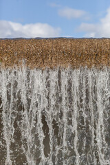 City river waterfall , side view of the falling water flow