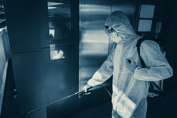 Man in virus protective suite and mask spraying alcohol cleaning covid19 infected area, Virus disinfection concept