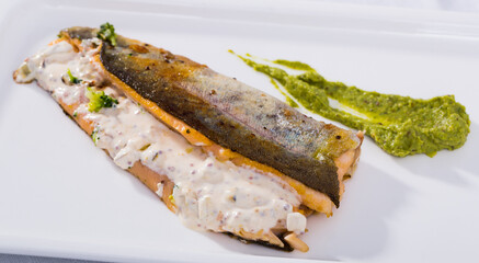 Dish of tasty steak of fried river trout fillet with sause tartar on plate