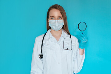 Pretty physician looking through magnifying glass, observing something closely