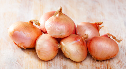 Whole fresh onion bulbs on wooden table. Healthy cooking ingredients