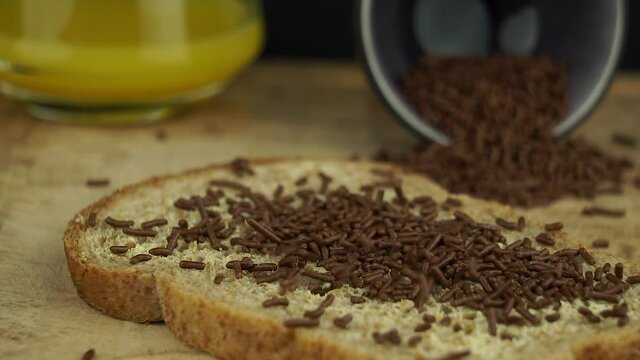 A typical dutch breakfast with a sandwich sprinkled with chocolate sprinkles. Slow motion