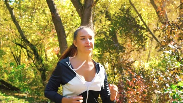 Athletic girl jogging in park on sunny day