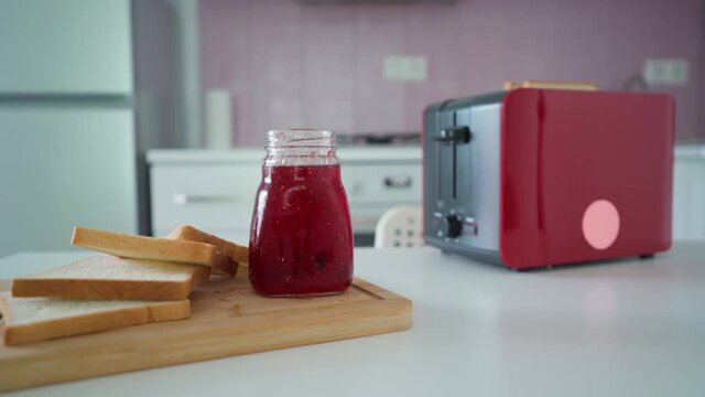 Using toaster for making crunchy roasted toast bread sandwiches with jam for snack