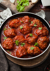 Traditional spicy meatballs in tomato sauce with pepper, garlic and parsley