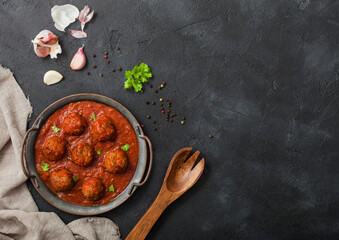 Traditional spicy meatballs in tomato sauce with pepper, garlic and parsley