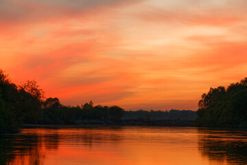 red bloody sunset on the river over water