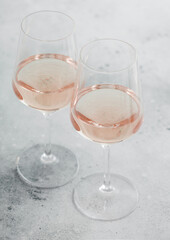 Two glasses of pink rose homemade summer refreshing wine on light background.
