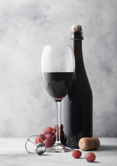 Homemade red wine in bottle with crystal glass corks with vintage corkscrew and grapes on light...