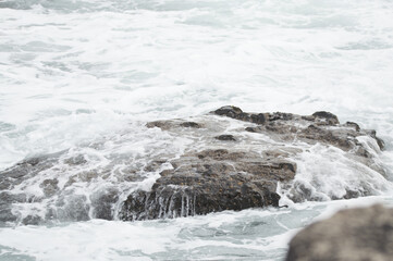 Waves crashing against rocks at the Giant's Causeway, Northern Ireland.