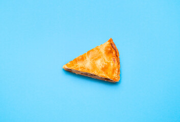Apple pie slice isolated on blue color. Last piece of the pie. Homemade dessert