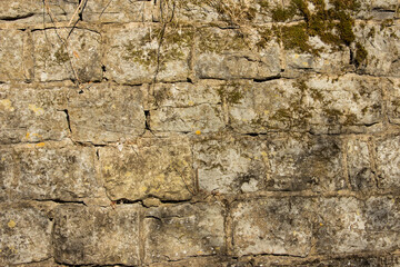 Close-up of masonry on an old stone wall covered with moss.