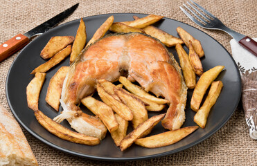 Salmon with fried potatoes. With bottle of cider. Asturias, Spain