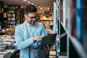 Fototapeta premium Middle age man choosing and reading books in modern bookstore.