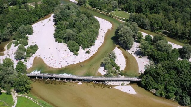 People enjoying this hot summer day at the famous Flaucher Steg at the Isar River, Munich, Germany