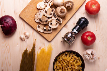 raw champignon mushrooms and tomatoes on the rustic wooden surface