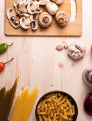 raw champignon mushrooms and tomatoes on the rustic wooden surface