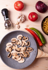 raw champignon mushrooms and tomatoes on the rustic wooden surface
