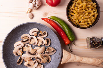 raw champignon mushrooms and tomatoes on the rustic wooden surface