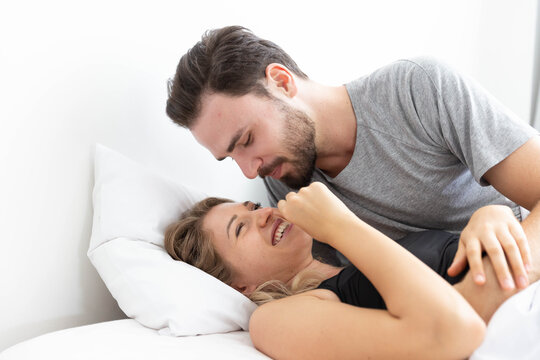 Caucasion couple feeling happy on bed in bedroom