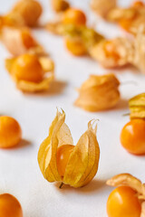 Cape gooseberry or Physalis on a white cloth background in 45 degree angle, focusing onto one with...
