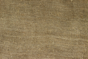 The structure of the threads of a natural burlap fabric close up.