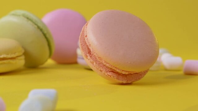 Close up macarone on yellow background to spin bakery food color sugar pearl french dessert delicious table macaroon slow motion