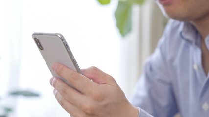 スマホを操作する男性の手元