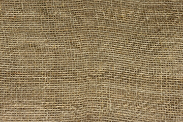 The structure of the threads of a natural burlap fabric close up.