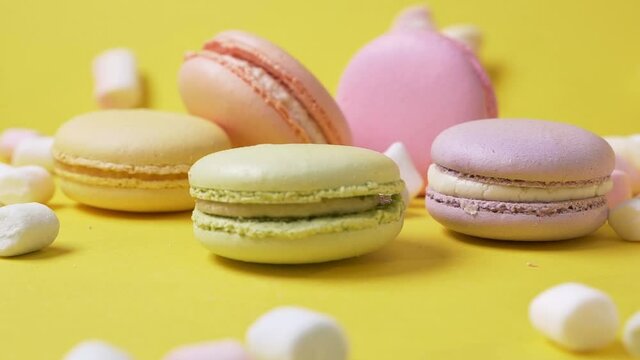 Green macarone on yellow background to spin bakery food color sugar pearl french dessert delicious table macaroon slow motion