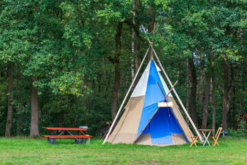 Colorful campsite with teepee or wigwam tents in green area
