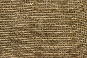 The structure of the threads of a natural burlap fabric close up.
