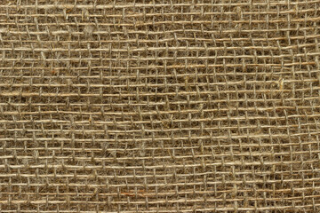 The structure of the threads of a natural burlap fabric close up.