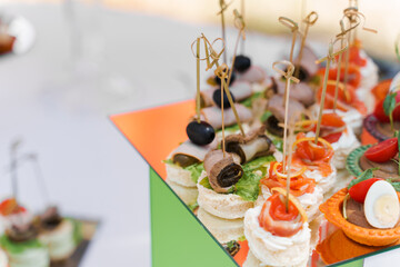 Meat canapes on white table on catering for company. Starter food for beginning of wedding ceremony. Advert for restaurants and cafe.