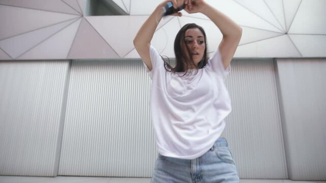 Young woman practicing modern dance on the street in slow motion