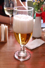 Glass with foamy drink on the table