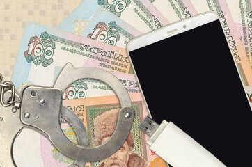 100 Ukrainian hryvnias bills and smartphone with police handcuffs. Concept of hackers phishing...