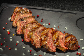 Steak with vegetables on a black plate