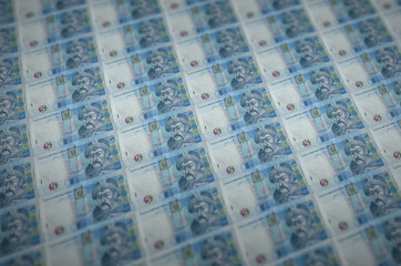 5 Ukrainian hryvnias bills printed in illegal money production conveyor. Collage of many fake...