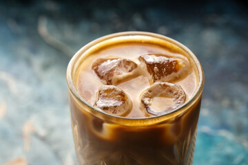 Iced coffee in a glass on the blurry background