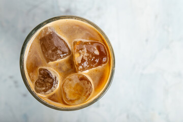 Iced coffee in a glass on the blurry background