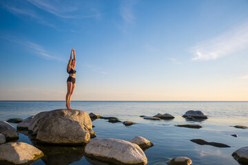 Fototapeta na wymiar Woman standing on seashore in Mountain pose