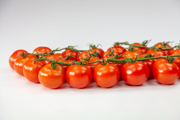 Tomato cherry on branch isolated on white background.
