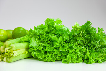 Green food. Limes, fresh celery stalk and lettuce on white background.