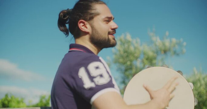 outdoor performance of a musician playing a tambourine. shot in slow motion