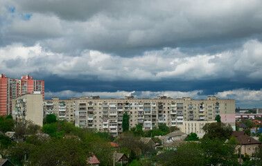 Fototapeta na wymiar View of the city with big dark clouds. Wallpaper of nature