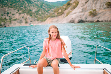 Little girl sailing on boat in clear open sea