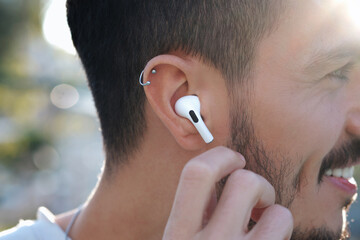 Bluetooth headphones on the ear of a young male person. 