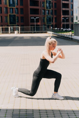 A girl in sportswear in the open air lunges, trains the gluteal muscles for weight loss