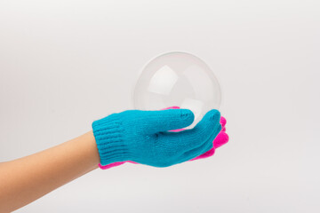 Child in brighte gloves holding soap bubble. happy childhood